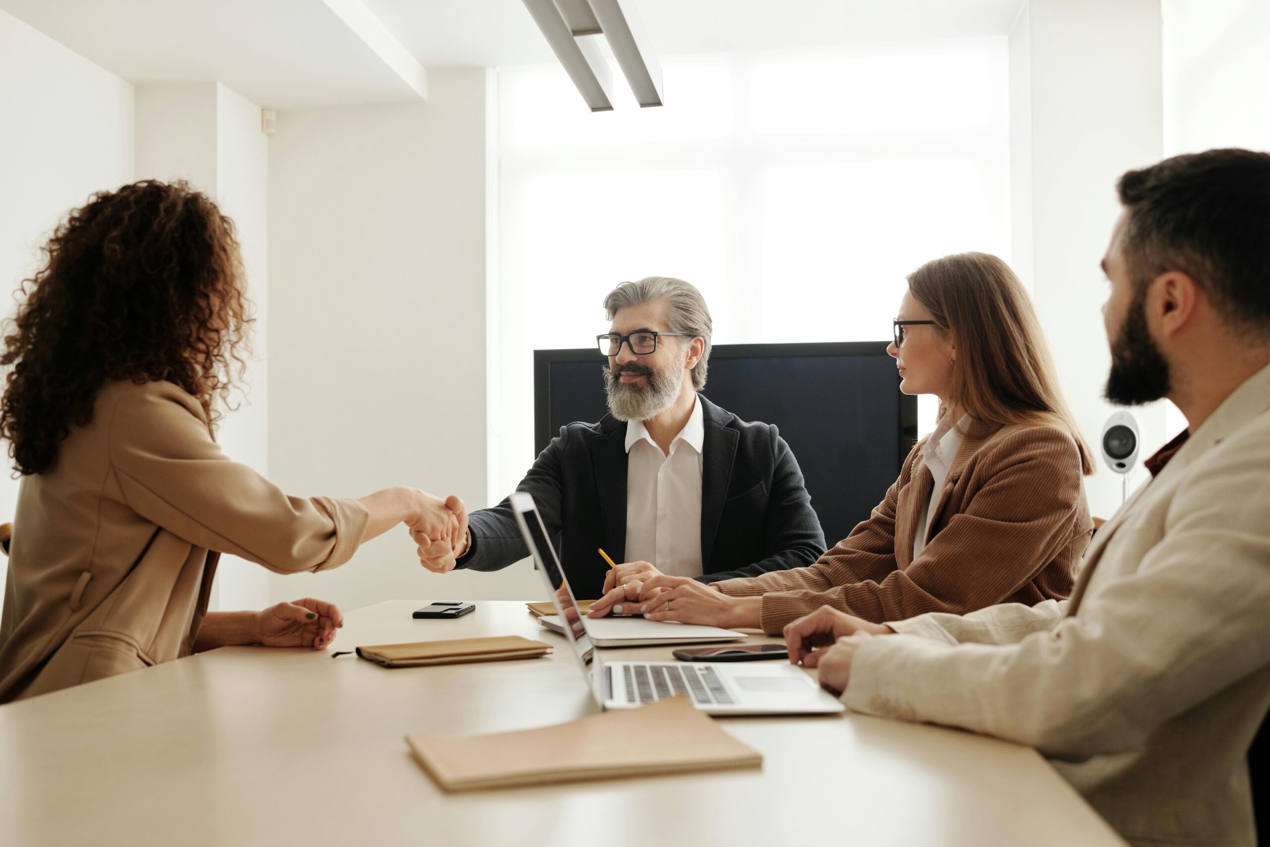 Services Colleagues in an office celebrating a successful negotiation with a handshake.