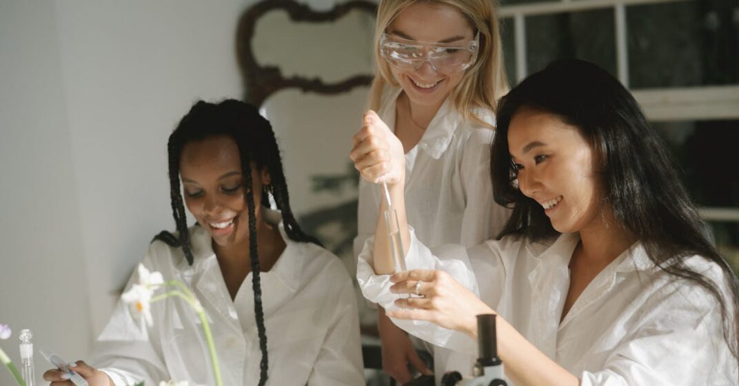 About Three women engaging in a science experiment with lab equipment and test tubes.